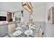 Bright dining area features a glass table, seating for eight, and views of the yard and modern living area at 816 Longboat Dr, Davenport, FL 33896
