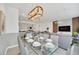 Bright dining area features a glass table, seating for eight, and views into a modern kitchen and living area at 816 Longboat Dr, Davenport, FL 33896