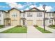 New townhomes featuring attached garages, well-manicured lawns and sidewalks on a beautiful, sunny day at 816 Longboat Dr, Davenport, FL 33896