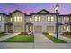 Exterior dusk shot of a new townhome featuring attached garages, well-manicured lawns, and sidewalk at 816 Longboat Dr, Davenport, FL 33896