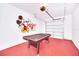 A garage features red floors, an air hockey table, and Mickey Mouse wall decor at 816 Longboat Dr, Davenport, FL 33896