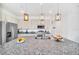 Island kitchen with stainless appliances, granite countertops and three overhead pendant lights at 816 Longboat Dr, Davenport, FL 33896