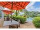 Outdoor seating with striped umbrellas near a tranquil pool area and lush greenery at 816 Longboat Dr, Davenport, FL 33896