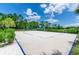 Sandy volleyball court surrounded by lush green landscaping under a sunny sky at 816 Longboat Dr, Davenport, FL 33896