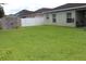 A large grassy backyard features a shed and a white fence for privacy, adding storage and security at 10722 Clover Walk Dr, Orlando, FL 32825