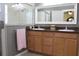 Bathroom with double sink vanity, a framed mirror, a glass-enclosed shower, and neutral wall color at 10722 Clover Walk Dr, Orlando, FL 32825