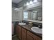 Bathroom with double sink vanity, a framed mirror, a glass-enclosed shower, and neutral wall color at 10722 Clover Walk Dr, Orlando, FL 32825