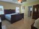 Cozy bedroom boasts natural light, a ceiling fan, en-suite bathroom, and a beautiful armoire at 10722 Clover Walk Dr, Orlando, FL 32825