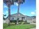 Inviting single-Gathering home with a two-car garage, complemented by lush landscaping and mature palm trees at 10722 Clover Walk Dr, Orlando, FL 32825