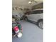 Well-organized garage with a car and motorcycle parked inside, featuring storage shelves and a clean, epoxy-coated floor at 10722 Clover Walk Dr, Orlando, FL 32825