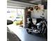 Clean garage space with a motorcycle, shelving, and a peek of a parked car, with an open garage door at 10722 Clover Walk Dr, Orlando, FL 32825