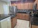 Kitchen with stainless steel refrigerator, granite countertops, and warm toned cabinets at 10722 Clover Walk Dr, Orlando, FL 32825