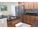 Well-lit kitchen featuring stainless steel refrigerator, granite countertops, and ample storage at 10722 Clover Walk Dr, Orlando, FL 32825