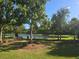 Scenic pond with lush green surroundings, mature trees, and a tranquil setting for community enjoyment at 10722 Clover Walk Dr, Orlando, FL 32825