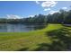 Scenic pond with lush green surroundings and mature trees offering a tranquil setting for community enjoyment at 10722 Clover Walk Dr, Orlando, FL 32825