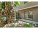 Backyard with tropical plants, wooden fence, concrete patio, and sliding glass doors into the house at 12155 Pepperdine Pl, Orlando, FL 32826