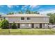 Two-story condo with neutral colors and a split rail fence around a lawn at 12155 Pepperdine Pl, Orlando, FL 32826