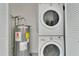 Convenient laundry area featuring stacked washer and dryer along with a water heater at 12155 Pepperdine Pl, Orlando, FL 32826