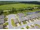 Wide aerial view of homes with brick driveways, green space, pond, and wooded area at 1309 Lombardi Ct, Kissimmee, FL 34759