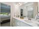 Bright bathroom features double vanity sinks, white countertops, and a large mirror at 1309 Lombardi Ct, Kissimmee, FL 34759