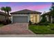 Charming single-Gathering home with a two-car garage, brick driveway, and well-maintained landscaping at 1309 Lombardi Ct, Kissimmee, FL 34759
