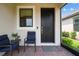 Welcoming front porch with seating and a stylish black front door, creating a cozy entrance at 1309 Lombardi Ct, Kissimmee, FL 34759