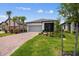 Inviting single-story home featuring lush landscaping, a paver driveway, and a screened porch at 1309 Lombardi Ct, Kissimmee, FL 34759