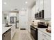 Stylish kitchen with white cabinets, stainless steel appliances, and a view of the stove and tile backsplash at 1309 Lombardi Ct, Kissimmee, FL 34759