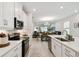Bright kitchen with white cabinetry, stainless steel appliances, and an open view to the dining and living areas at 1309 Lombardi Ct, Kissimmee, FL 34759