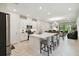 Open-concept kitchen with white cabinetry, stainless steel appliances, island seating, and tile flooring at 1309 Lombardi Ct, Kissimmee, FL 34759