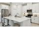 Bright kitchen featuring white cabinets, stainless steel appliances, and a spacious island with seating at 1309 Lombardi Ct, Kissimmee, FL 34759