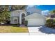 Charming two-story home with attached two-car garage, manicured lawn and mature trees at 13129 Cog Hill Way, Orlando, FL 32828