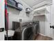 Well-lit laundry room features modern washer and dryer, overhead storage shelves, and convenient access at 13129 Cog Hill Way, Orlando, FL 32828