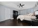 Spacious main bedroom featuring a tray ceiling, ceiling fan, hardwood floors, and a television on a dresser at 13129 Cog Hill Way, Orlando, FL 32828