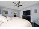 Bright main bedroom with a ceiling fan, tray ceiling, hardwood floors, and access to the main bathroom at 13129 Cog Hill Way, Orlando, FL 32828