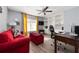 Inviting home office space with a red couch, built-in bookshelves, and natural light at 13129 Cog Hill Way, Orlando, FL 32828