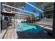 Enclosed pool with a screened enclosure, clear blue water, patio furniture, a grill, and palm trees at 13129 Cog Hill Way, Orlando, FL 32828