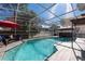 Enclosed pool area with a screened enclosure, patio furniture, gazebo, hot tub, and a pool at 13129 Cog Hill Way, Orlando, FL 32828