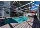 Backyard pool area featuring a screened enclosure, clear blue water, and a barbecue grill at 13129 Cog Hill Way, Orlando, FL 32828