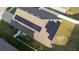 An aerial view of a roof with solar panels installed, showcasing a green lawn with lush landscaping at 1383 Buckeye Trace Blvd, Winter Haven, FL 33881