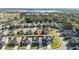 Neighborhood aerial view showcases the home, white fencing, sidewalks, and a large lake in the distance at 1383 Buckeye Trace Blvd, Winter Haven, FL 33881