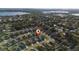Aerial view of a suburban neighborhood with lake in background and a home marked with a pin at 1383 Buckeye Trace Blvd, Winter Haven, FL 33881