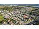 Aerial view of suburban houses with lawns, trees, and a lake in the distance, home marked with a pin at 1383 Buckeye Trace Blvd, Winter Haven, FL 33881