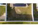 Aerial view of backyard with a well-kept lawn, a fence, trees, and solar panels on the roof at 1383 Buckeye Trace Blvd, Winter Haven, FL 33881