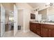 Bathroom featuring dual sink vanity with wood cabinets, tile floors, and access to main bedroom at 1383 Buckeye Trace Blvd, Winter Haven, FL 33881