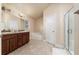 Bathroom with dual sinks, wood cabinets, a soaking tub, and separate glass-enclosed shower at 1383 Buckeye Trace Blvd, Winter Haven, FL 33881