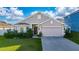 Charming single-story home features a two-car garage, well-manicured lawn, and mature shrubbery at 1383 Buckeye Trace Blvd, Winter Haven, FL 33881