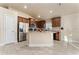 Well-lit kitchen with stainless steel appliances, wood cabinets, and a granite-topped island at 1383 Buckeye Trace Blvd, Winter Haven, FL 33881