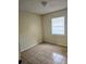 An empty bedroom with tile floors, a window with blinds, and neutral colored walls, offering a blank canvas at 141 Varner Sw Dr, Winter Haven, FL 33880