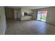 Open-concept living room with tile flooring, sliding glass doors and an adjacent kitchen area at 15 Clear Way, Ocala, FL 34472